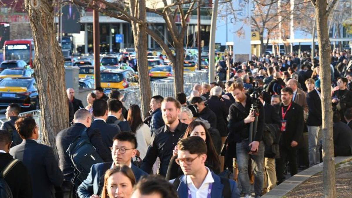 Cientos de congresistas del Mobile World Congress hacen cola para coger un taxi.