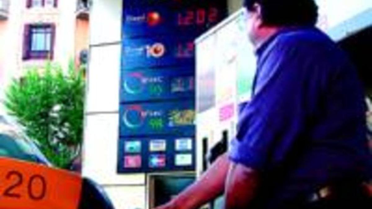 Un taxista llena el depósito, ayer en una gasolinera de Barcelona.