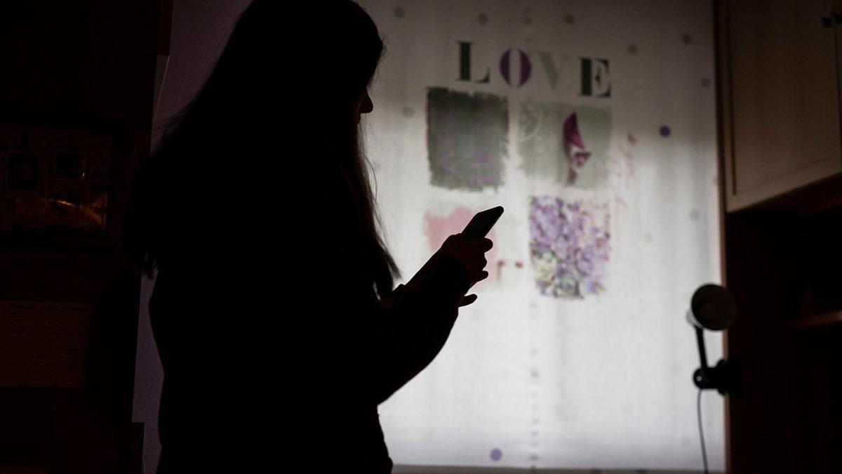Una adolescente mira la pantalla de su 'smartphone'.