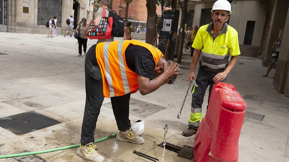 Un trabajador de la construcción se refresca ante los efectos del calor