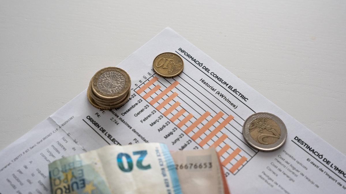 Dinero sobre una factura de la luz.