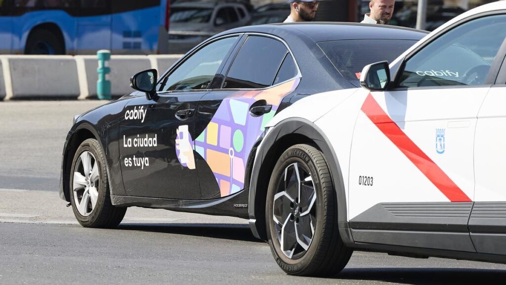 Un vehículo de Cabify junto a un taxi en Madrid.