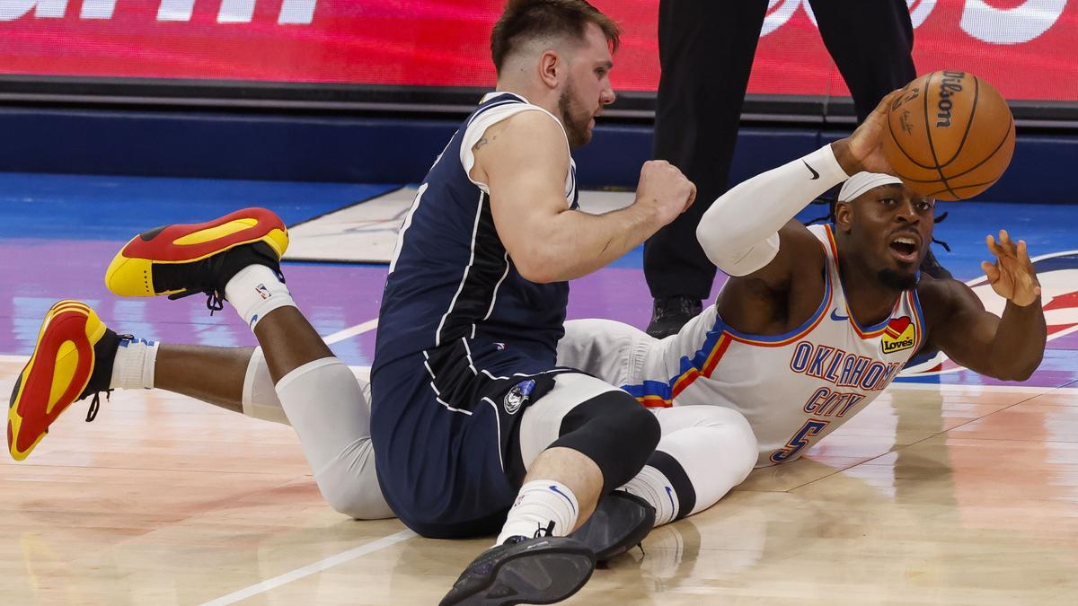 Doncic pelea un balón en el suelo.