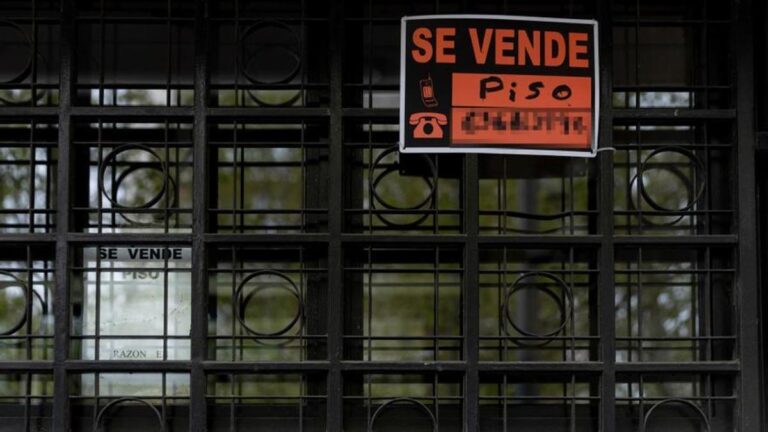 Un cartel de 'se vende' en el portal de un edificio.