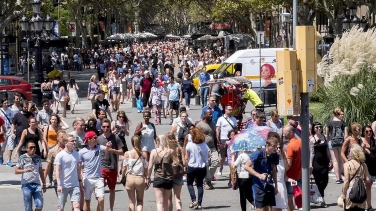 Turistas pasean por el final de las Ramblas, en Barcelona.