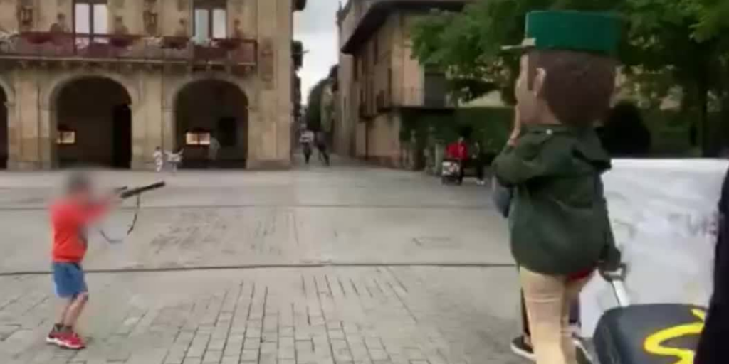 Un niño apunta con una falsa escopeta a un cabezudo de la Guardia Civil en Oñate
