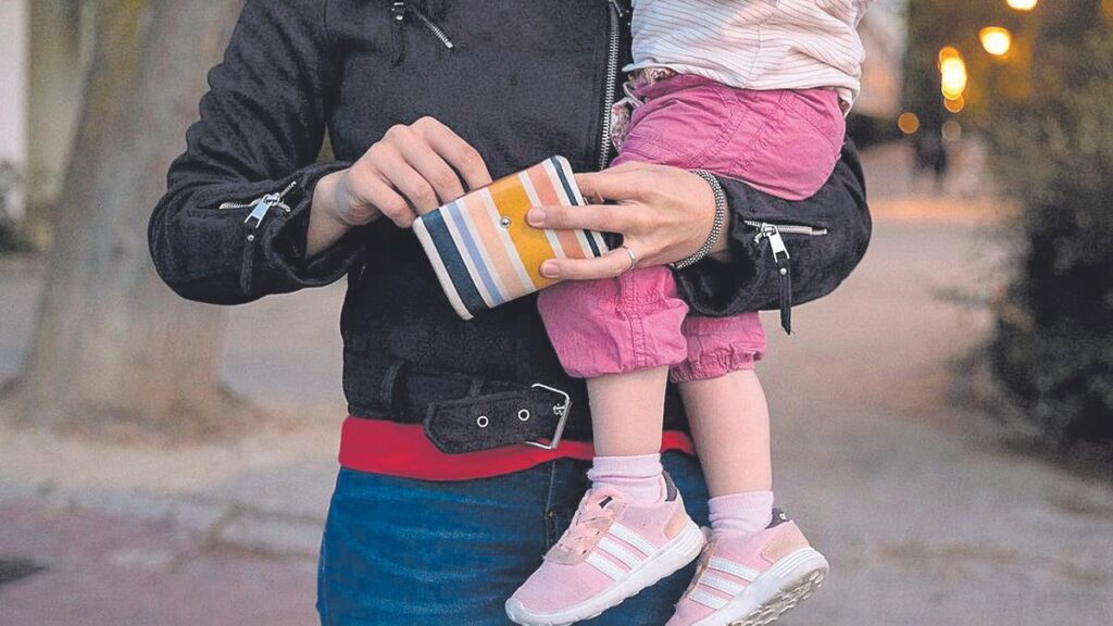 Una madre con su hija pequeña en brazos.