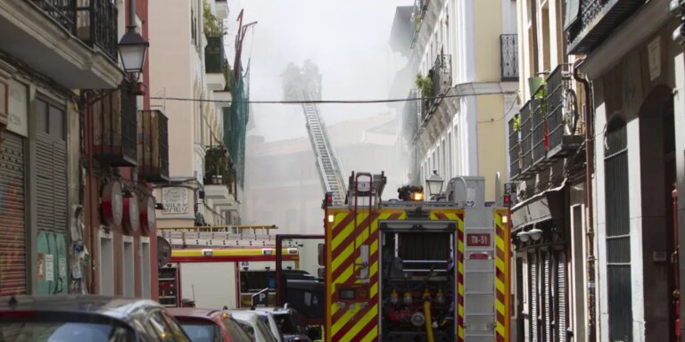 Bomberos rescatan a una mujer por el tejado de un descansillo en llamas en Lavapiés